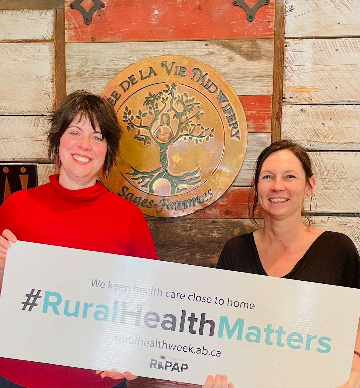 Chantal and an unnamed coworker carrying a sign saying #Rural Health Matters